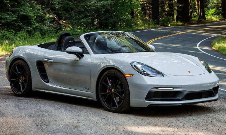 Silver Porsche Boxster GTS on a tree lined road