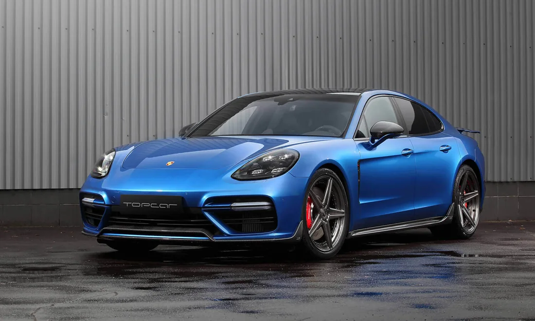 Blue Porsche Panamera beside a corrugated wall